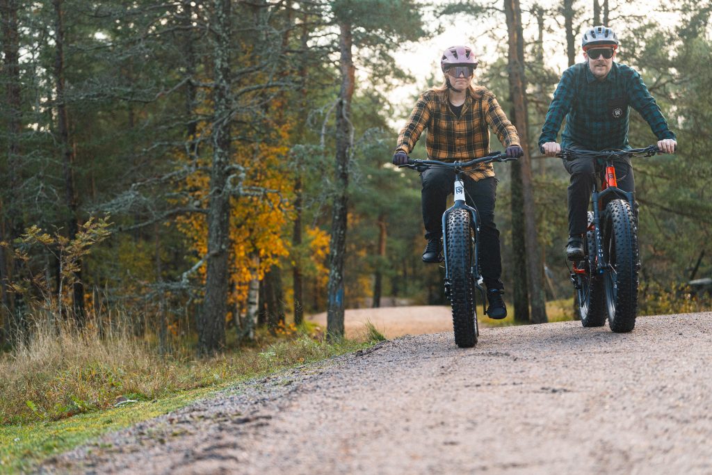 Nainen ja mies maastopyöräilee